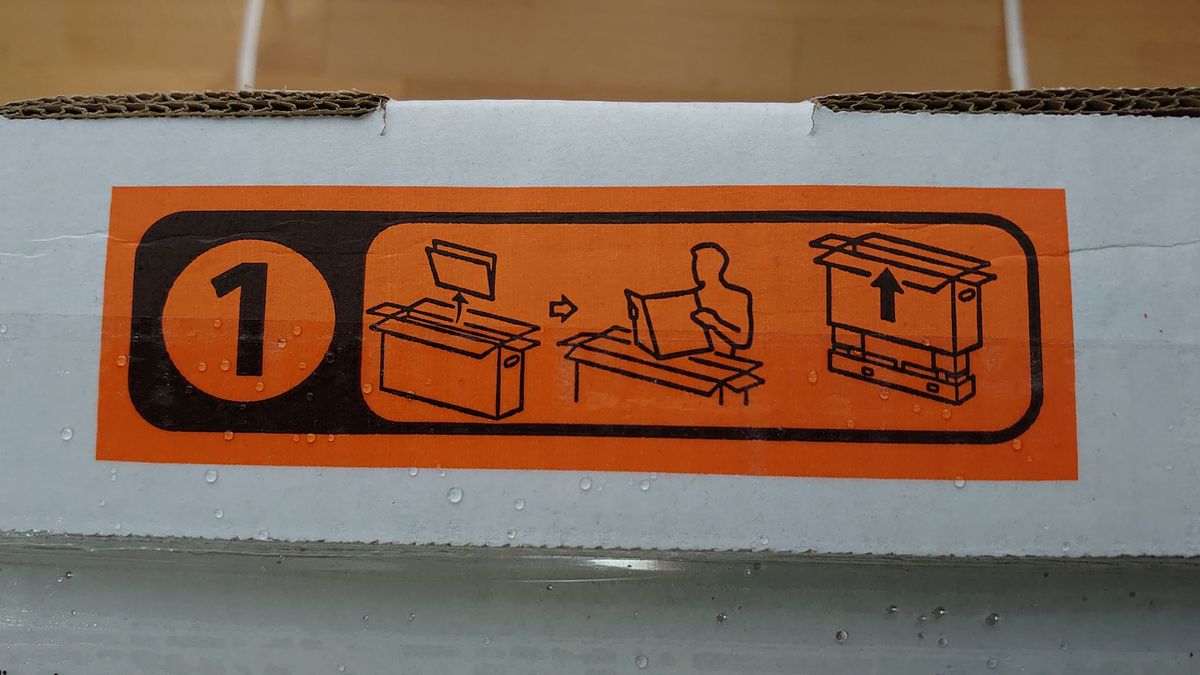 Der auffällige orange Aufkleber auf dem Karton zeigt die ersten Schritte.