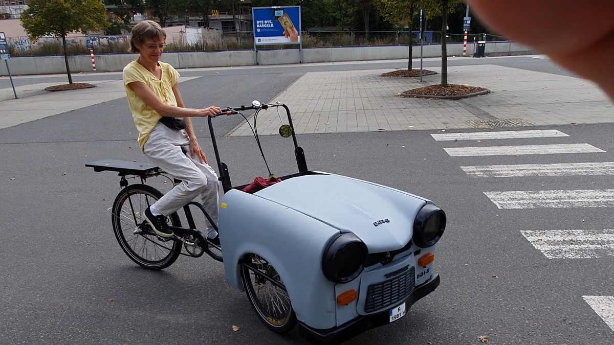 Sie ist mit ihr Spitzen Trabi 3 Fahrrad unterwegs.png